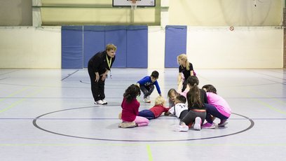Trainerin erklärt Kindern Übung